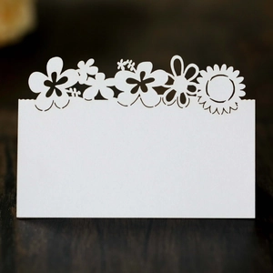Elegant laser-cut sunflower place card for weddings on dark wood texture background