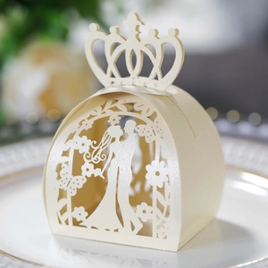 Close-up of laser-cut ivory wedding favor box with crown top and couple silhouette