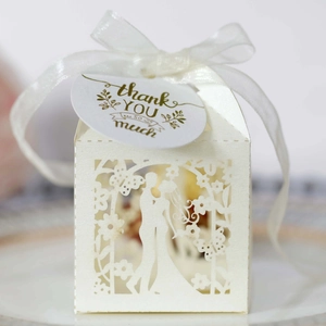 Detailed laser-cut ivory wedding favor box featuring bride and groom silhouette with ribbon