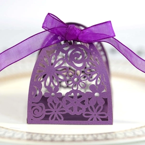 Detailed laser-cut hollow floral pattern on purple wedding favor box with silk ribbon