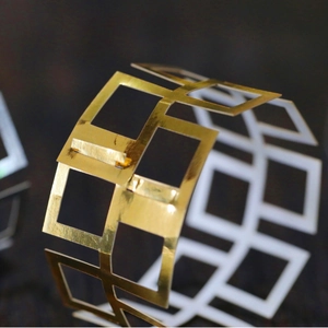 Rond de serviette doré géométrique évidé avec finition polie miroir pour les mariages