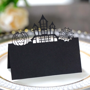 Laser-cut Halloween place card with spider web and castle motifs on a white plate