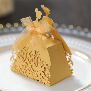 Macro shot of laser-cut wedding candy box with silk ribbon and pearl paper finish