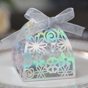 Detailed macro view of holographic laser-cut candy box with silver ribbon and floral pattern
