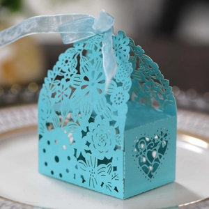Macro detail of laser-cut light blue wedding favors box with floral patterns and ribbon