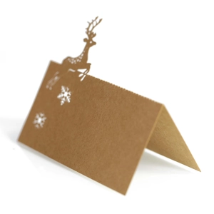 Detail of laser-cut reindeer and snowflake on brown kraft paper Christmas table card