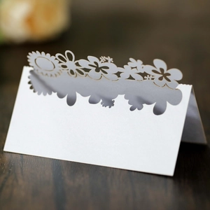 Macro shot of laser-cut sunflower place card with white pearlescent texture for weddings