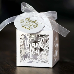 Detailed laser-cut floral pattern on a white Thank You gift box with a silk ribbon