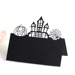 Laser-cut Halloween place card featuring a black castle, spider web, and pumpkin design
