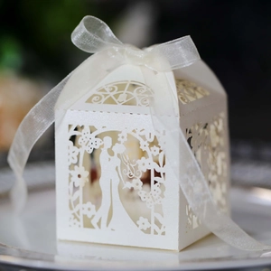 Macro detail of laser-cut wedding candy box with silhouette and organza ribbon bow