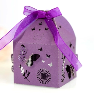 Macro view of purple laser-cut candy box with butterfly hollow patterns and silk ribbon