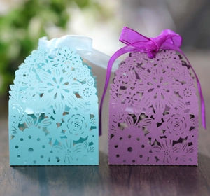 Detailed laser cut floral patterns on light blue and purple wedding candy gift boxes