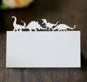 Détail de marque-places dinosaures découpés au laser sur une table en bois