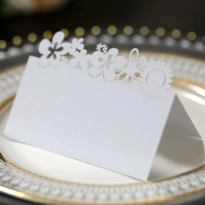 Macro view of white laser-cut sunflower place card with elegant hollowed floral pattern
