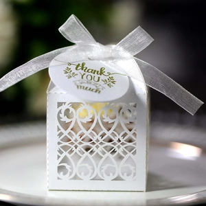 Detail of white laser-cut favor box with transparent ribbon and thank you gift tag