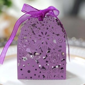 Detail of laser-cut purple gift box with floral patterns and a matching ribbon bow