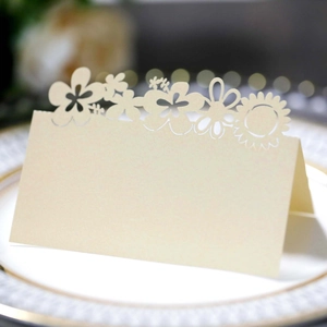 Elegant beige laser-cut sunflower place card displayed on a gold-rimmed plate