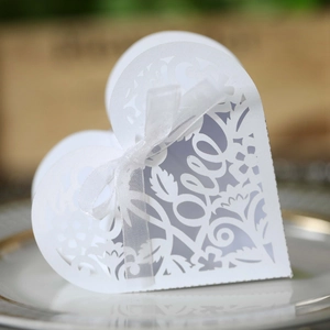 Detail of white laser-cut heart candy box with Love lettering and silk ribbon bow