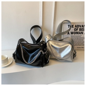 Detail of glossy wrinkled leather tote with chain and metallic eyelet shoulder straps