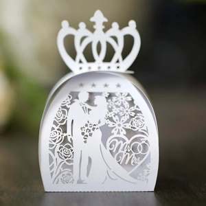 Macro detail of laser-cut crown wedding favor box with Mr & Mrs bride and groom design