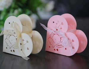Dettaglio di scatole regalo a forma di cuore color crema e rosa con motivi a elefante