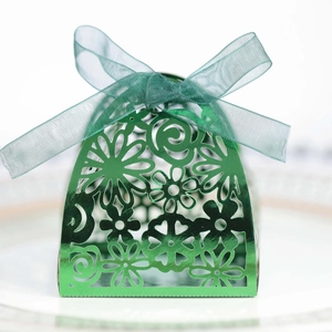 Close-up of green laser-cut gift box with floral patterns and a matching satin ribbon bow