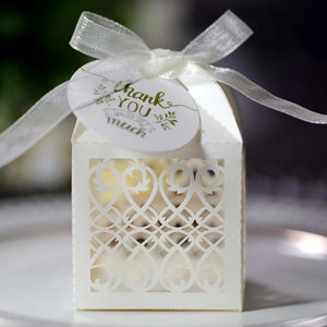 Detail of laser-cut wedding favor box with white ribbon and Thank You hanging tag