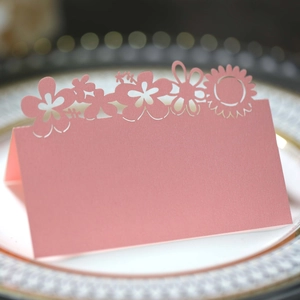 Detailed macro of pink laser-cut sunflower place card on elegant dinner plate