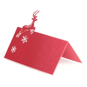 Detail of red laser-cut Christmas reindeer place card with hollow snowflake design
