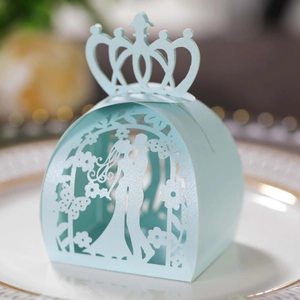 Macro view of laser-cut light blue wedding favor box with pearl luster and crown detail