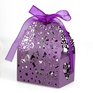 Macro view of laser-cut floral patterns on purple pearlescent paper candy gift box