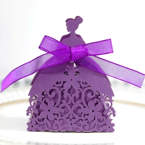 Macro detail of purple laser-cut wedding favor box with floral pattern and silk bow