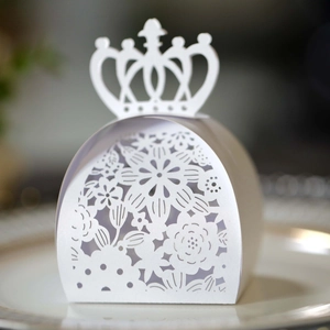 Detail of white laser-cut candy box featuring crown handle and floral hollow patterns