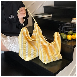 Détail de sacs fourre-tout en maille à rayures jaunes en deux tailles avec anses en cuir