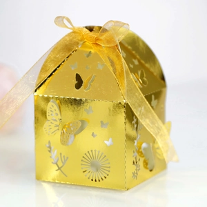 Detail of laser-cut butterfly pattern on golden gift box with elegant ribbon bow