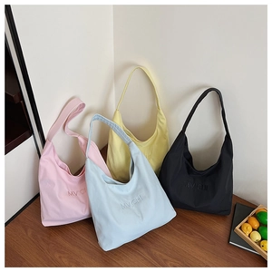 Detail view of MVICHI canvas tote bags in four pastel colors with embroidered letters