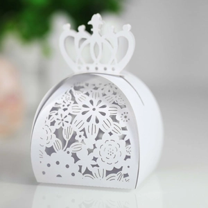 Detail of white laser-cut gift box featuring intricate crown and floral hollow pattern