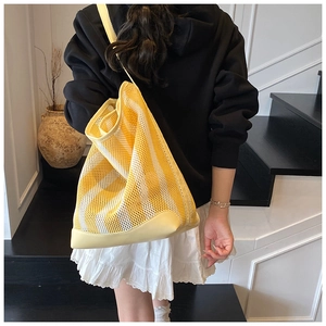 Detail of striped mesh tote bag with yellow leather trim shown from back view