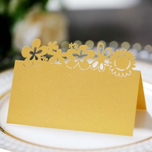 Elegant gold laser-cut sunflower table place card on a white porcelain dinner plate