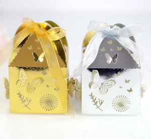 Detail view of gold and silver laser-cut butterfly gift boxes with organza ribbons