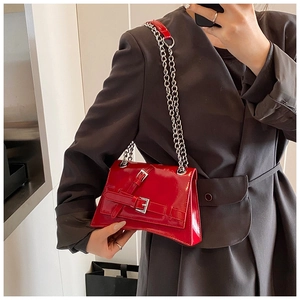 Detail of red patent leather chain bag with geometric cuts and silver hardware accents