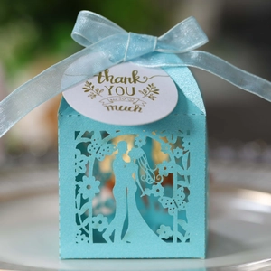 Macro detail of laser-cut Tiffany blue wedding favor box with ribbon and thank you tag