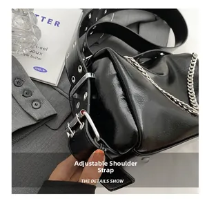 Detail of adjustable wide shoulder strap with silver eyelets and chain on black bag