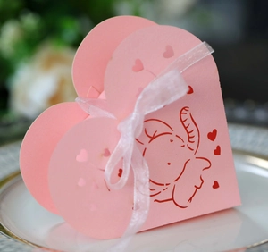 Dettaglio della scatola regalo rosa a cuore con elefante e nastro bianco in seta