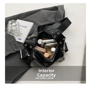 Detail of black leather tote interior showing storage capacity and eyelet strap