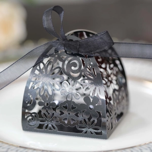 Macro shot of black laser-cut hollow gift box with elegant floral patterns and ribbon