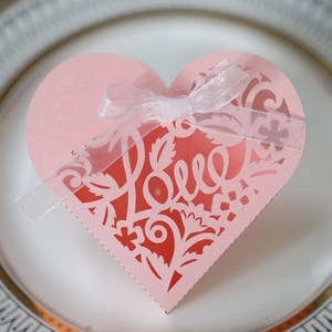 Pink heart-shaped laser-cut wedding favor box with Love engraving and ribbon