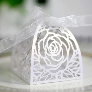 Dettaglio macro dei motivi floreali a rosa tagliati al laser sulla scatola bianca elegante
