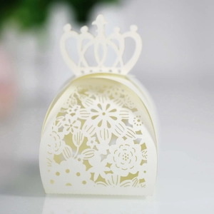 Detailed laser-cut white favor box with elegant floral patterns and crown top design