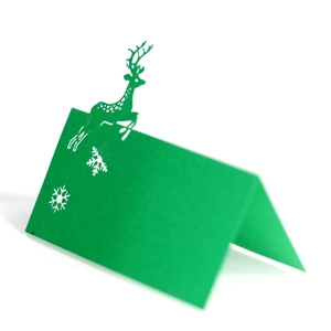 Detail of green laser-cut Christmas reindeer place card with hollow snowflake patterns